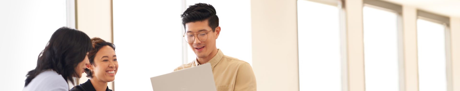 Three people looking at a laptop