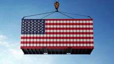 Trade cargo container with the American flag on it being lifted onto a ship 