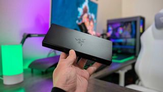 The Razer USB4 Dock held in the hand, showing the emblazoned Razer logo.