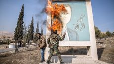 Fighters burn a picture of Bashar al-Assad close to Syria's border with Lebanon