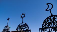 Symbols of Christianity, Judaism and Islam are seen in a display.