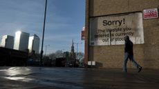 A man walks past graffiti artist Banksy's 2011 mural "Sorry The Lifestyle You Ordered Is Currently Out Of Stock" in London's East End