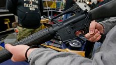 A man holds a Bushmaster AR-15