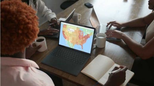 People meeting looking at a map on a laptop.