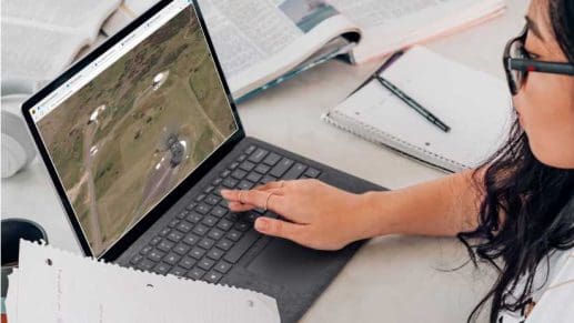 A woman looking up satellite images on a laptop.