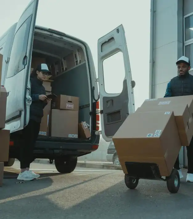 people hauling cardboard boxes from a truck