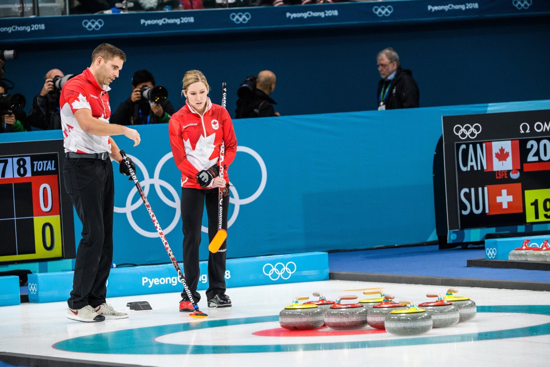 Two curlers look at the rocks in the rings