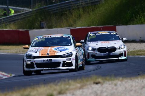 Zwei Autos von VW und BMW liefern sich ein Rennen auf dem Nürburgring