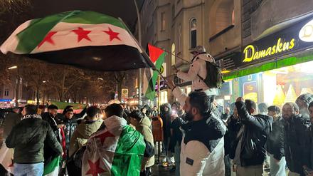 Syrer versammeln sich im Bezirk Neukölln mit Flaggen vor der Bäckerei Damaskus und feiern den Vormarsch der Rebellen auf Damaskus. 