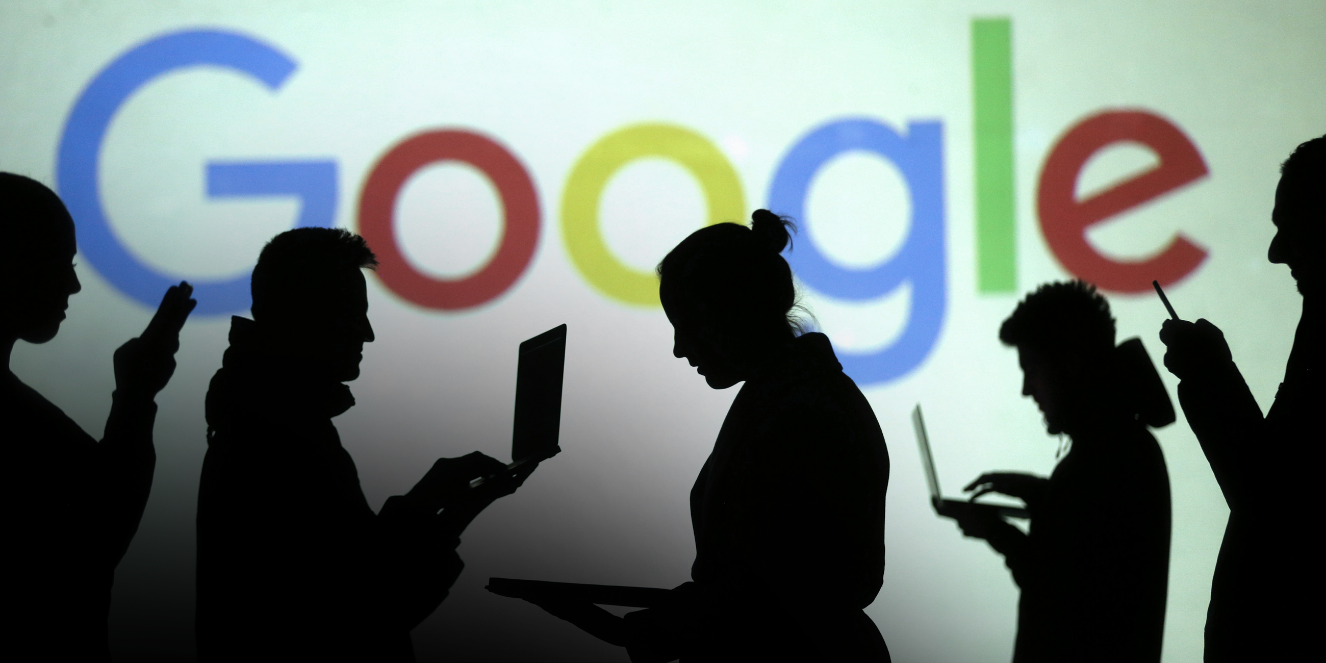 Schatten von Laptop-Nutzern vor Google Logo