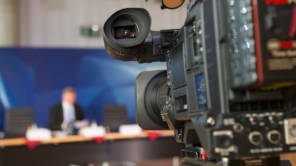 Eine Fernsehkamera ist auf ein Podium gerichtet.