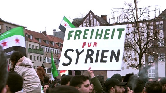 "Freiheit für Syrien" steht auf einem Schild während einer Kundgebung nach dem Sturz des syrischen Assad-Regimes. © picture alliance/dpa | frm 