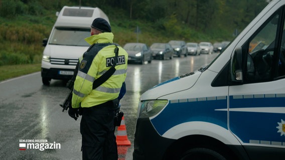 Ein Polizist steht an einer Grenzkontrolle. © NDR 