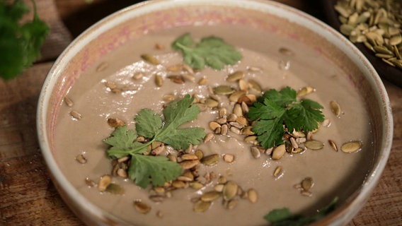 Eine Champignon-Pastinaken-Suppe mit Petersilie und Koriander auf einem Teller angerichtet. © NDR 