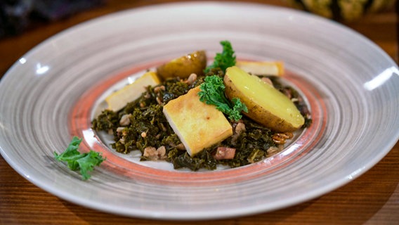 Vegetarischer Grünkohl auf einem Teller angerichtet mit Pellkartoffeln und Räuchertofu. © NDR 