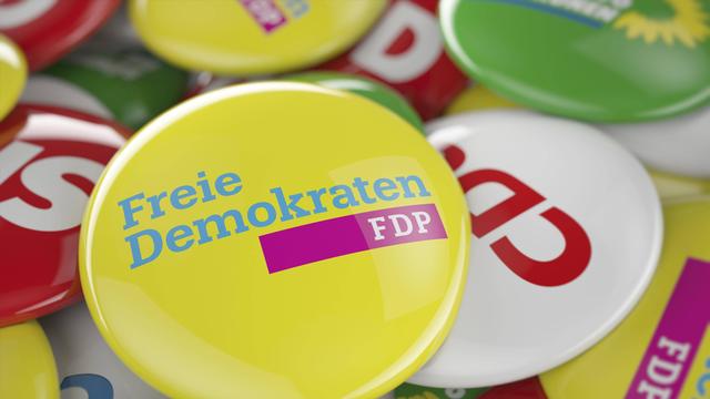 Ein FDP Button liegt auf den Buttons anderer deutscher Parteien.