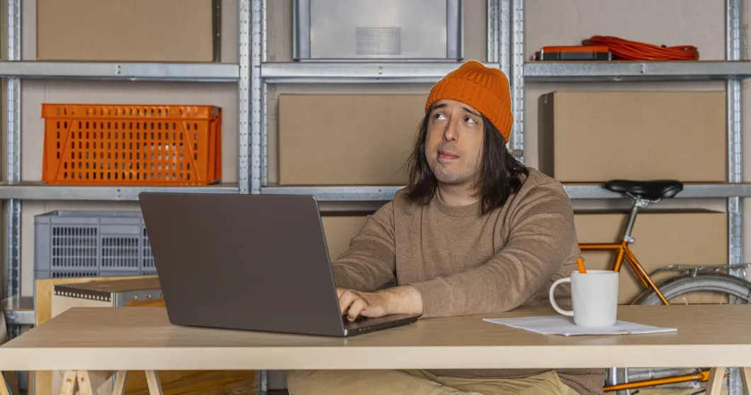 Mann mit Laptop am Schreibtisch im Büro