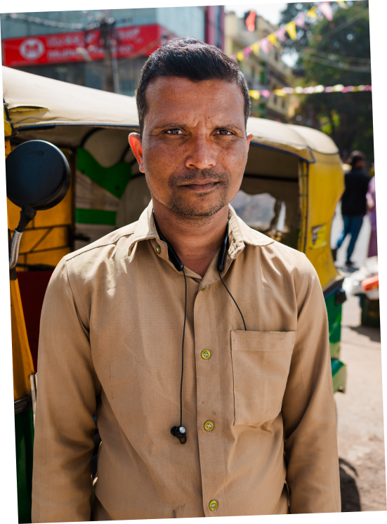 Middle-aged Indian man standing in a tan button-up shirt.