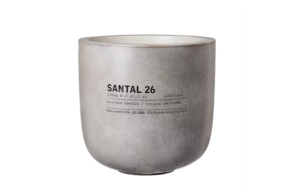 A grey pot with black text, possibly a Santal candle