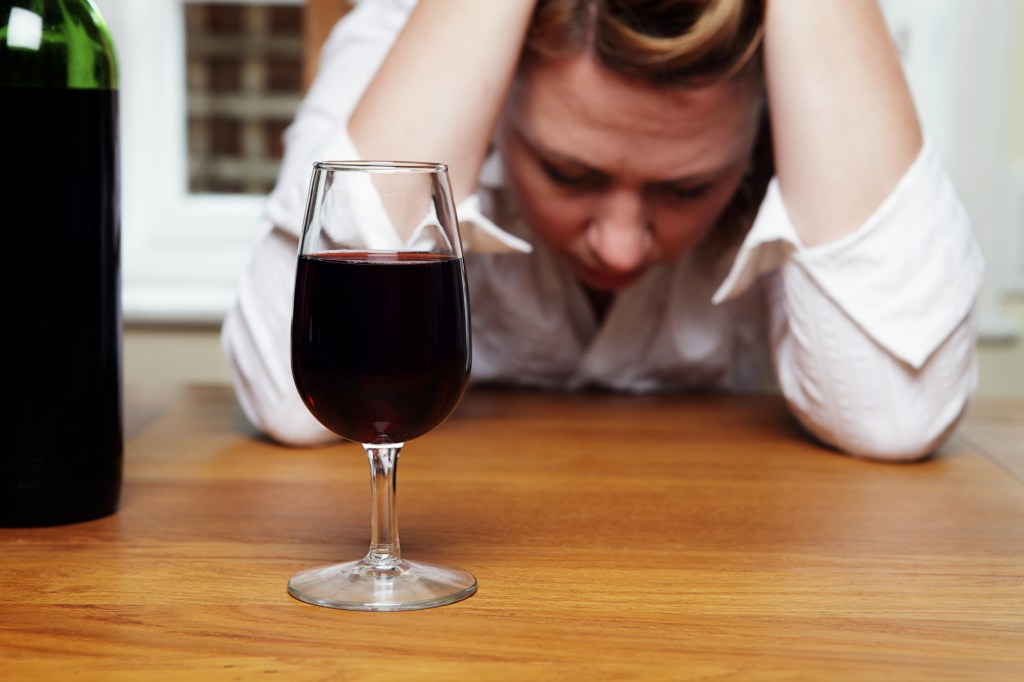 A woman upset while drinking red wine