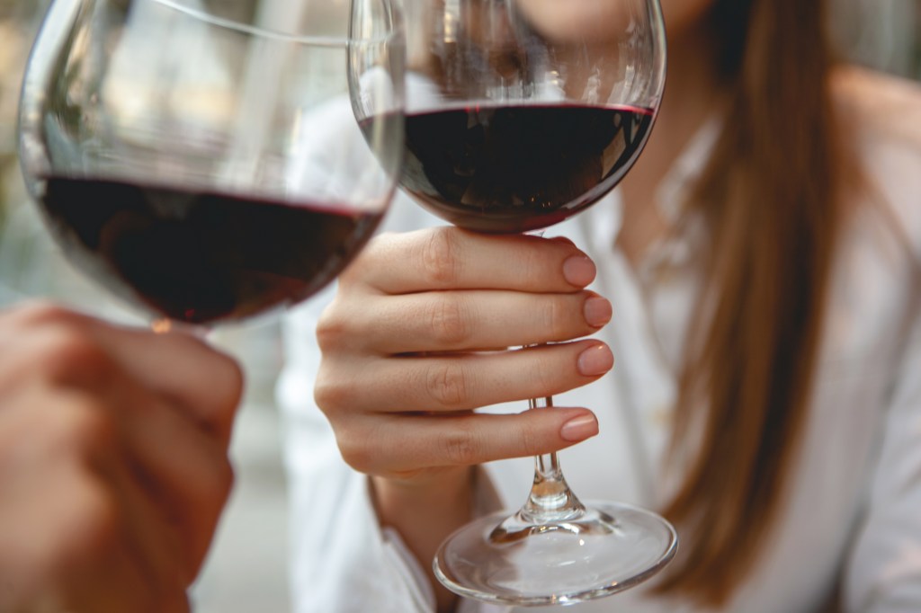 Two people toasting with red wine