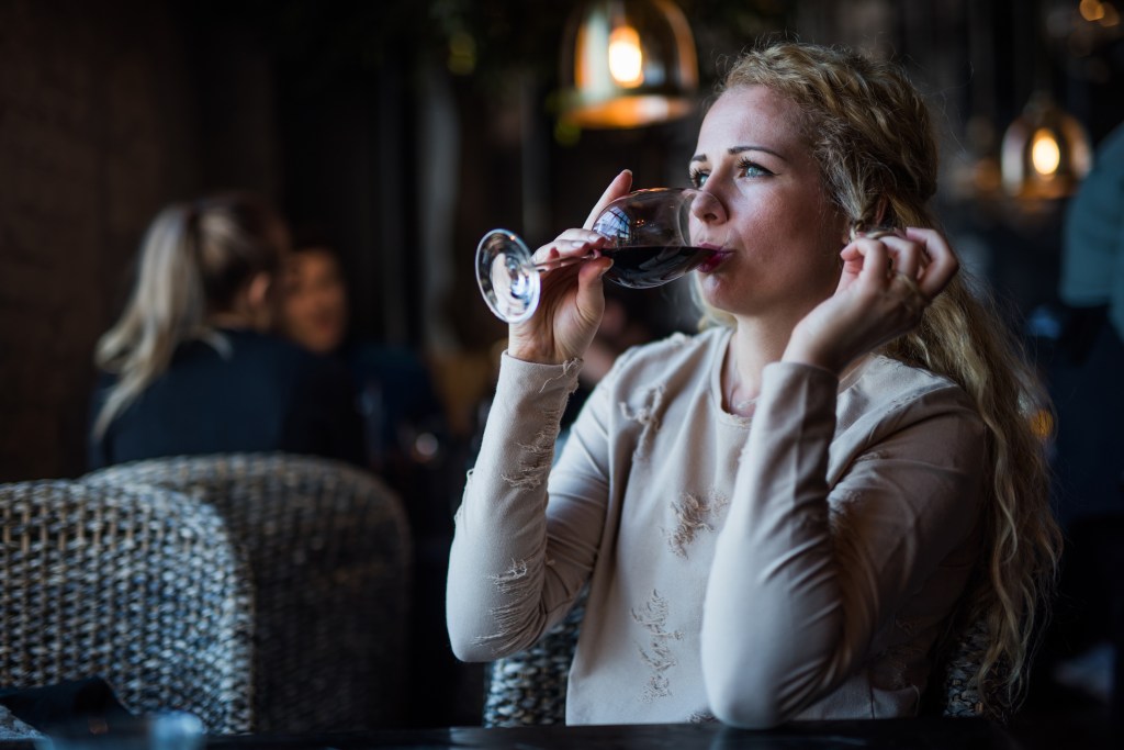 A woman drinking red wine