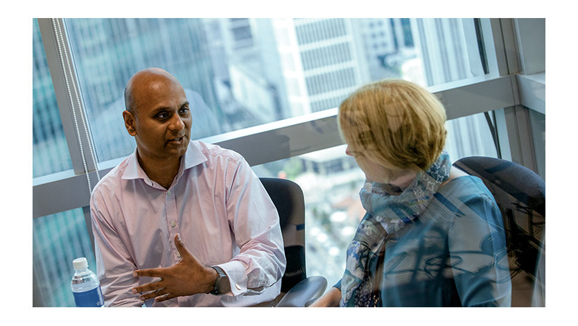 Two coworkers talking while sitting in an office building