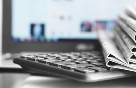 Folded newspapers on a laptop.