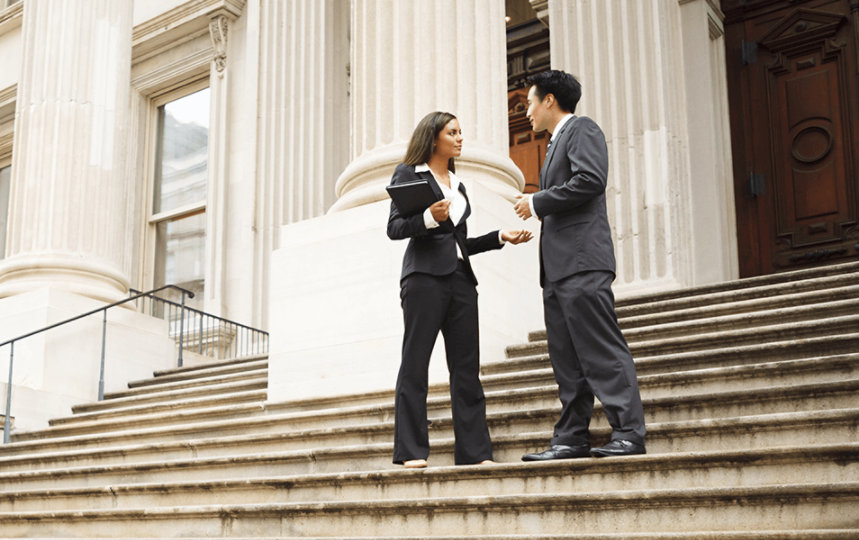 Man and a woman having a discussion in front of a courthouse