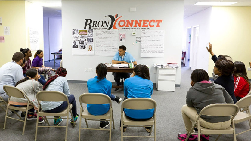 Participants gathered in a room talking with a BronxConnect employee.