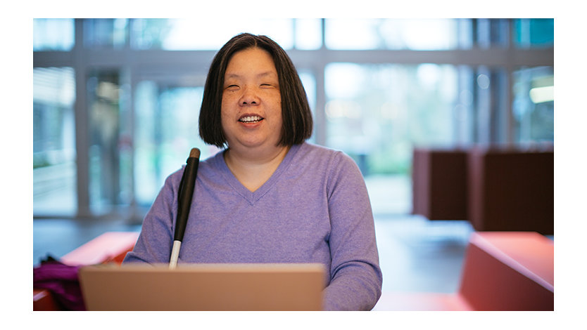 A woman with low-vision sitting at a computer