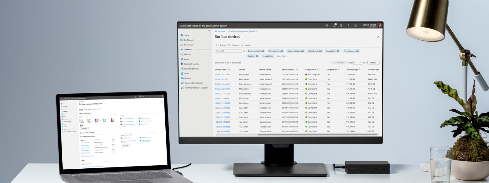 A desk with a Surface device and monitor displaying a management interface onscreen