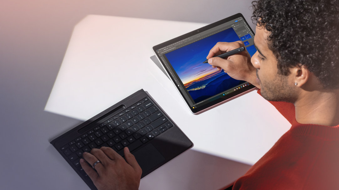 A man using a Surface Pro 11ᵗʰ Edition with a detachable Surface Pro Flex Keyboard and Surface Slim Pen