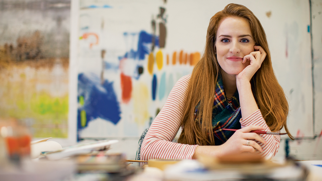 A person holding a paintbrush and smiling 