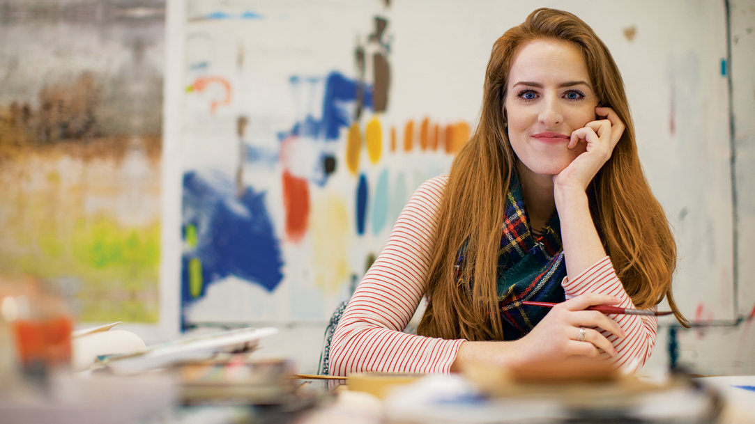 A person holding a paintbrush and smiling