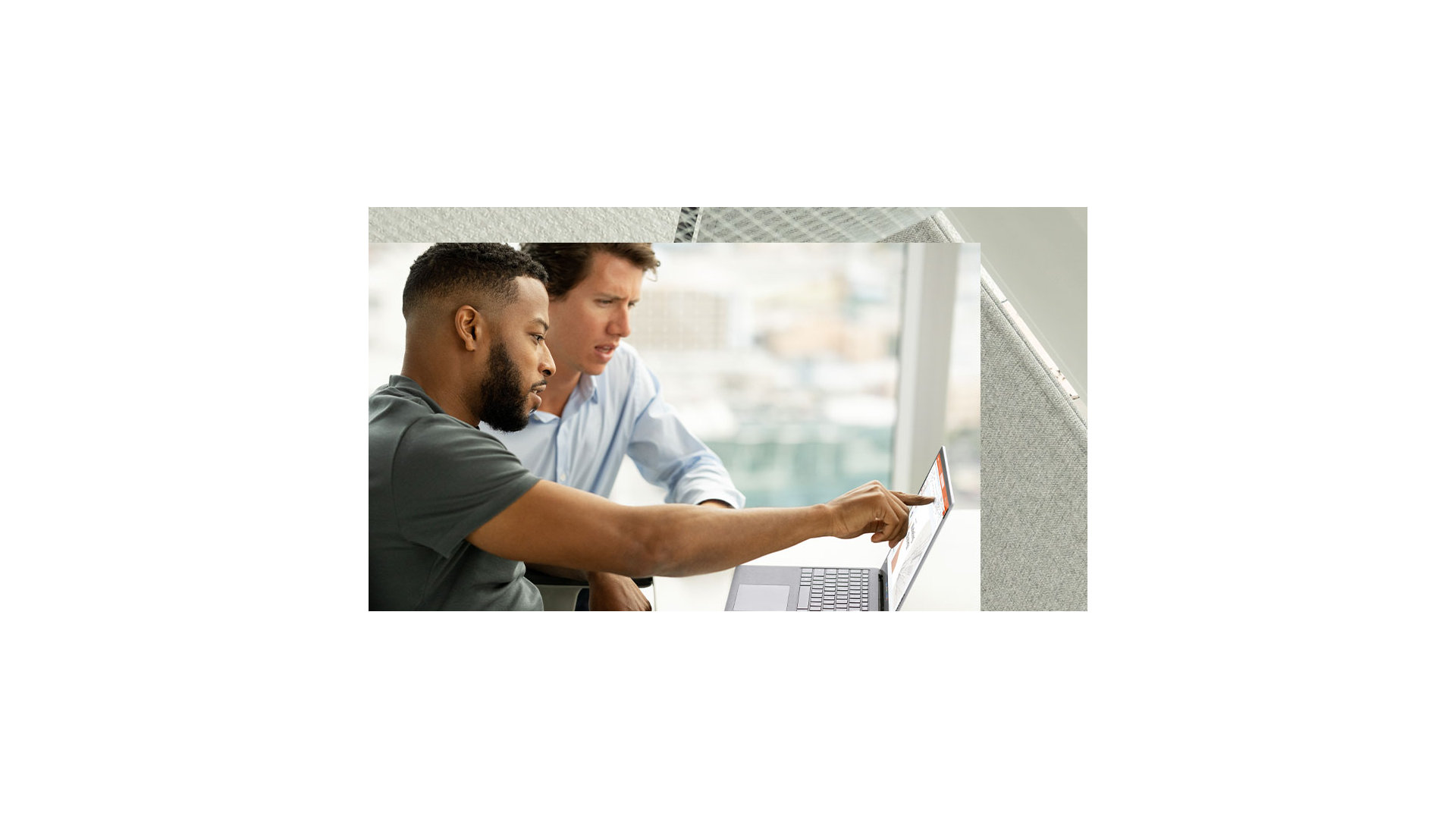 A person is seen using their finger to interact with the screen of a Surface Laptop 5 device