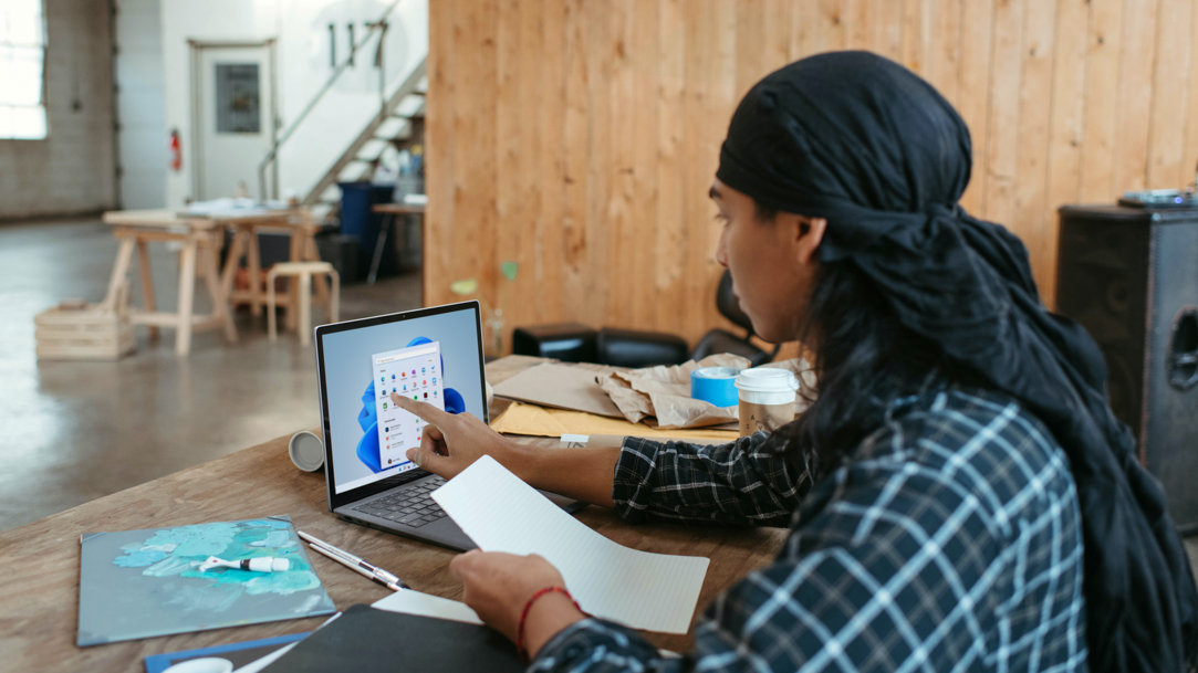 A person sitting at a table using a laptop computer