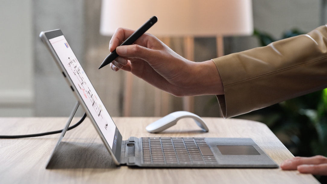 A person writing with a Surface Slim Pen