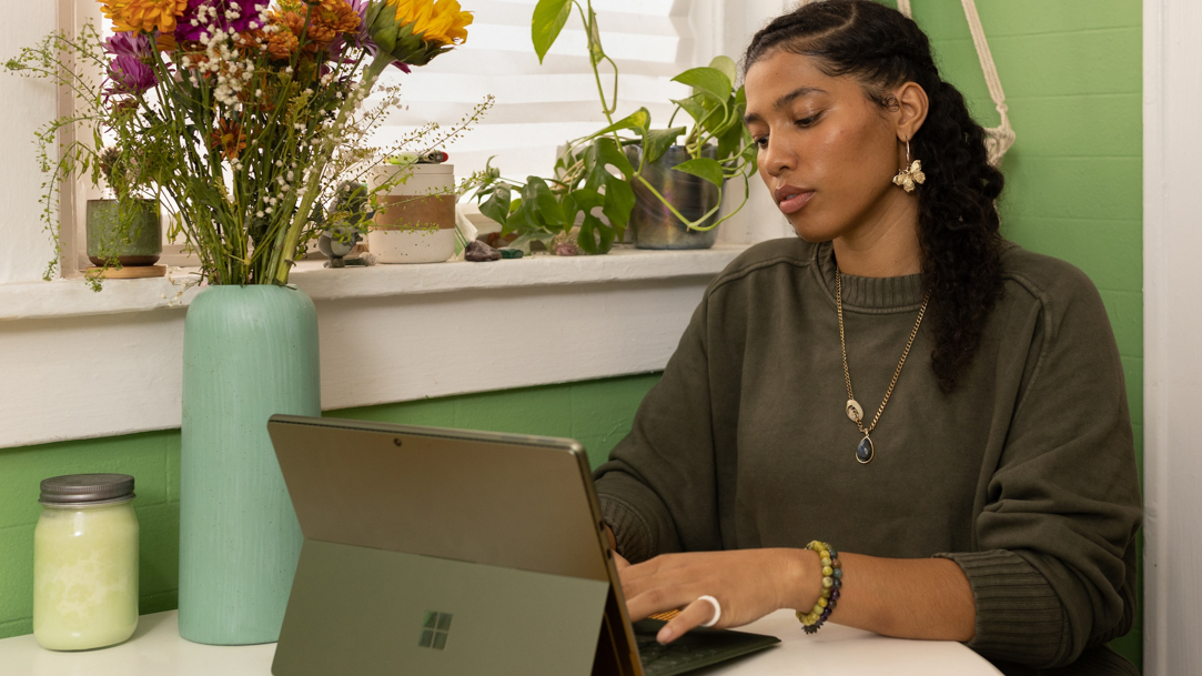 A woman sitting at a table using a laptop computer