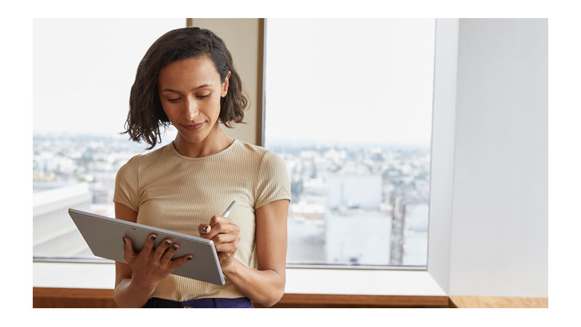 A woman writes with Surface Pen on her Surface tablet