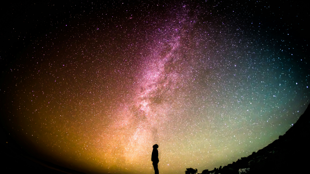 An image of a man standing beneath the vastness of the universe