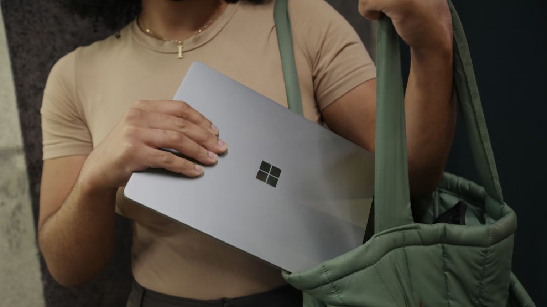 An image of a woman putting her Surface laptop in her bag