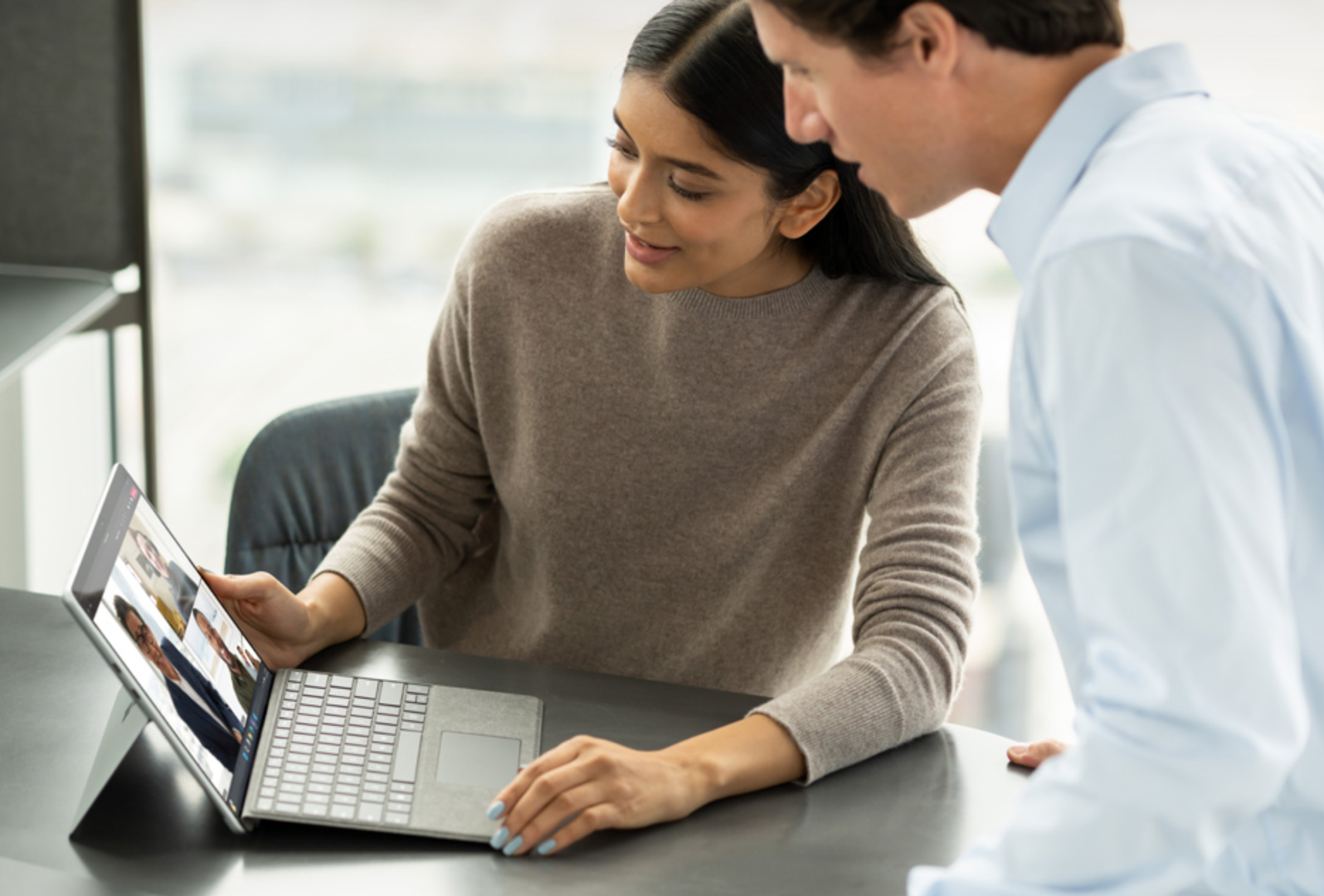 Coworkers sharing a Surface device for a virtual meeting