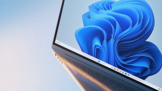 A tilted, partial view of an open Microsoft Windows laptop with the blue bloom screen.