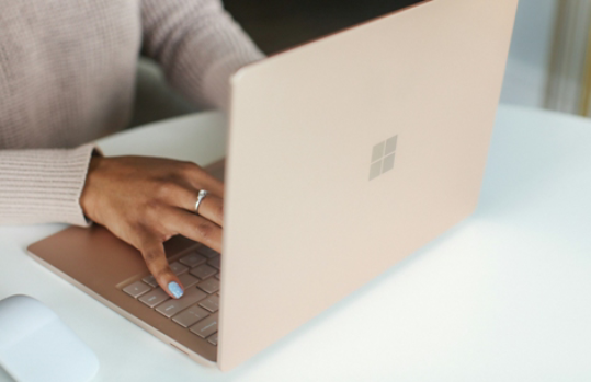 Image of a woman's hands typing on a Microsoft Surface device