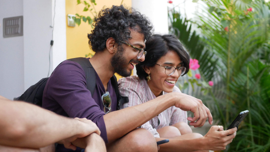 Man and woman smiling at a phone