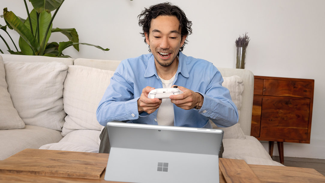 Man using a wireless controller to play games on a 2 in 1