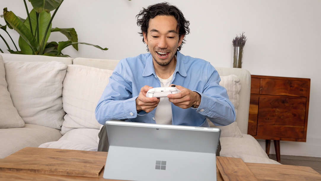 Man using a wireless controller to play games on a 2-in1