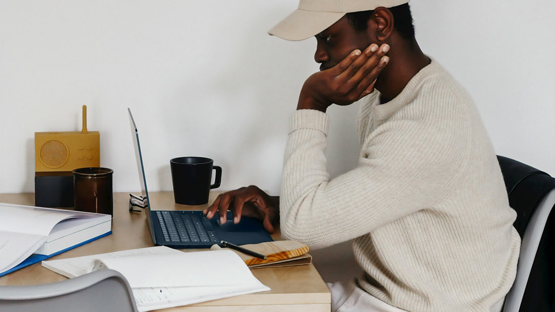 Person at a table working on a laptop