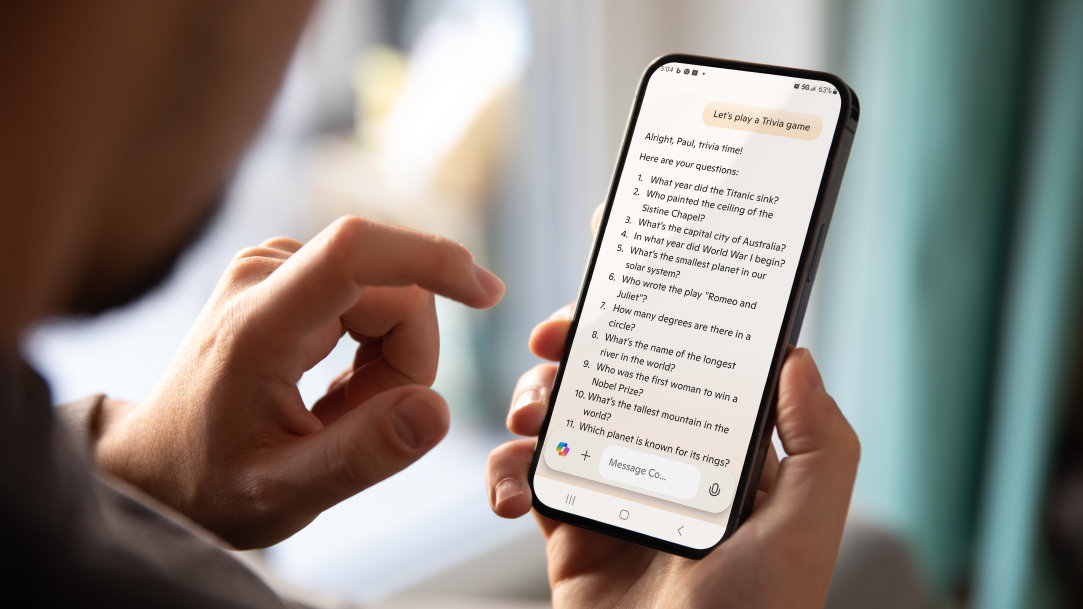 Person holding a mobile phone with the Copilot app open providing questions for trivia time